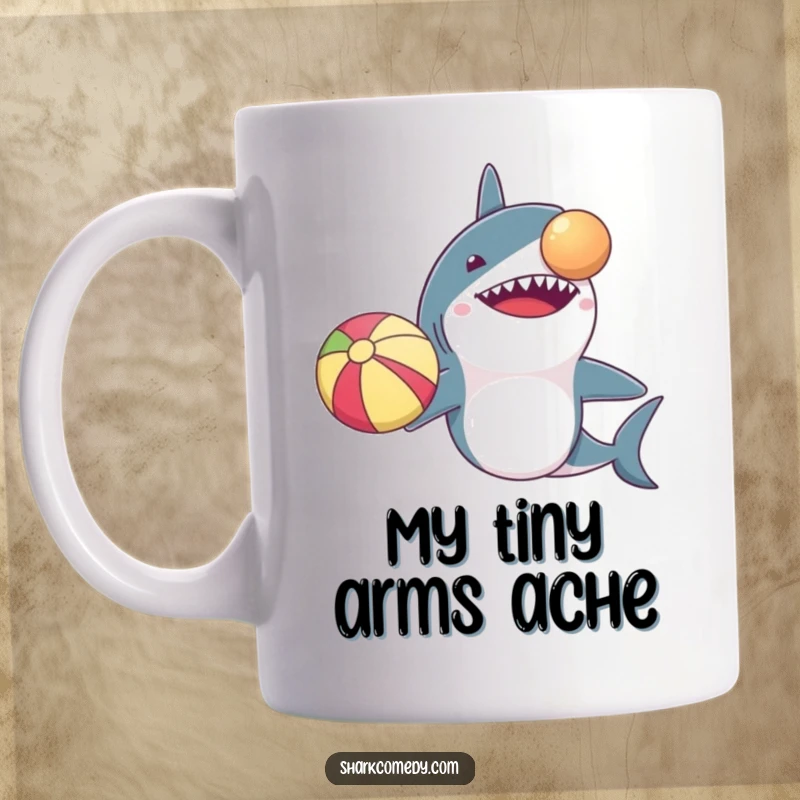 Funny mug showcasing a determined shark with disproportionately small arms, balancing a beach ball on its nose, symbolizing effort and humor.