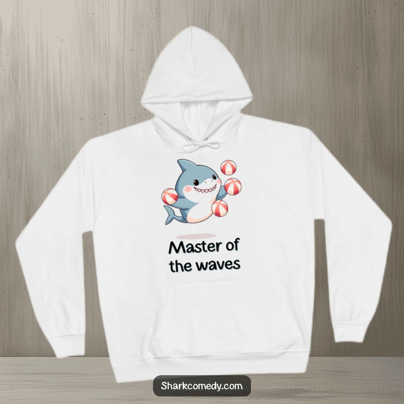 Funny hoodie depicting a cute, excited shark masterfully juggling beach balls, ideal for cozying up with a dose of marine humor.