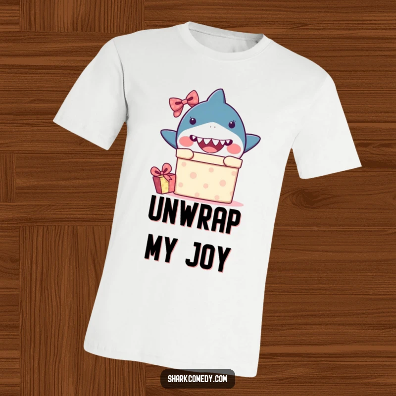 Funny kawaii shark t-shirt featuring a shark peeking from a gift box with eyes wide in surprise, great for humorous wear.